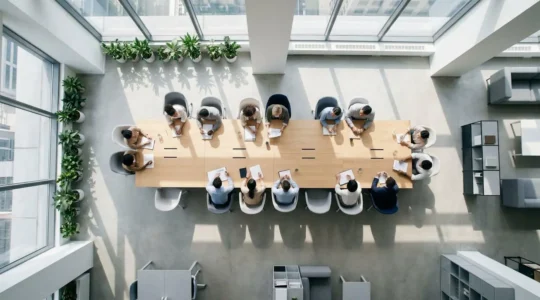 Vue en plongée d'une équipe collaborative travaillant sur une stratégie de sécurité informatique dans un environnement de bureau moderne